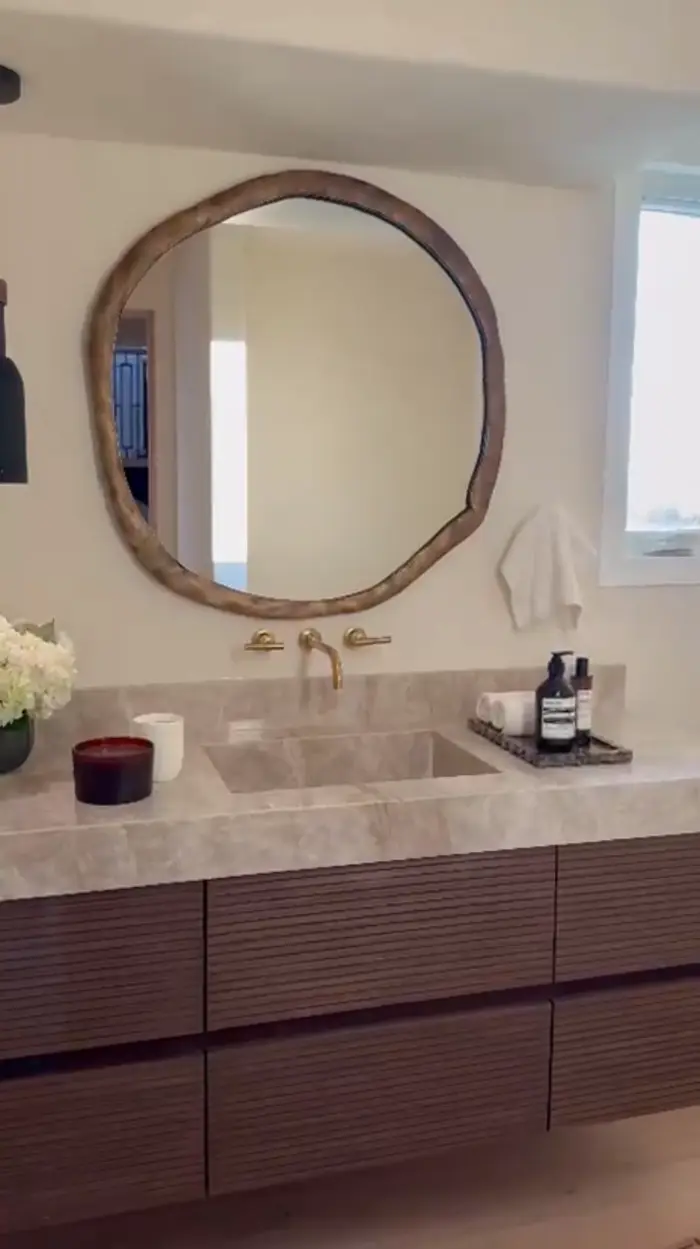 Renovated bathroom vanity with stone counter and round mirror, Dana Point home renovation